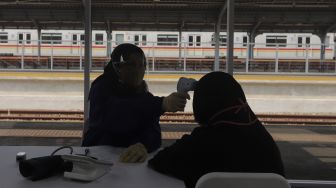 Tenaga kesehatan memeriksa kondisi kesehatan warga yang akan mendapatkan vaksin COVID-19 di Stasiun Jakarta Kota, Jakarta, Rabu (28/7/2021). [Suara.com/Angga Budhiyanto]