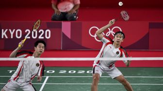 Pebulutangkis ganda putra Indonesia Marcus Fernaldi Gideon/Kevin Sanjaya Sukamuljo mengembalikan kok ke arah ganda putra Malaysia Aaron Chia/Wooi Yik Soh dalam perempat final Olimpiade Tokyo 2020 di Musashino Forest Sport Plaza, Tokyo, Jepang, Kamis (29/7/2021). ANTARA FOTO/Sigid Kurniawan