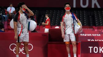 Pebulutangkis ganda putra Indonesia Marcus Fernaldi Gideon/Kevin Sanjaya Sukamuljo meninggalkan lapangan seusai kalah dari ganda putra Malaysia Aaron Chia/Wooi Yik Soh dalam perempat final Olimpiade Tokyo 2020 di Musashino Forest Sport Plaza, Tokyo, Jepang, Kamis (29/7/2021).  ANTARA FOTO/Sigid Kurniawan