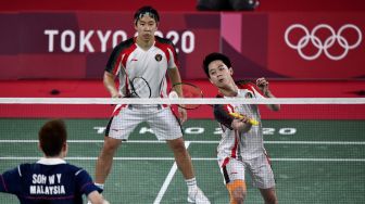 Pebulutangkis ganda putra Indonesia Marcus Fernaldi Gideon/Kevin Sanjaya Sukamuljo mengembalikan kok ke arah ganda putra Malaysia Aaron Chia/Wooi Yik Soh dalam perempat final Olimpiade Tokyo 2020 di Musashino Forest Sport Plaza, Tokyo, Jepang, Kamis (29/7/2021). ANTARA FOTO/Sigid Kurniawan