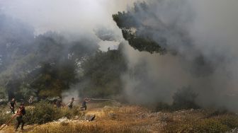 Relawan membantu memadamkan kebakaran hutan di daerah Qubayyat di wilayah terpencil Akkar, Lebanon, pada (29/7/2021). [JOSEPH EID / AFP]