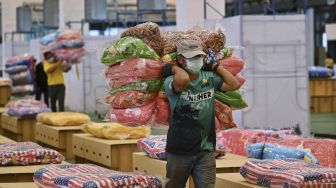 Pekerja menyiapkan kasur dan selimut untuk tempat tidur kardus di rumah sakit lapangan COVID-19 di dalam gudang Bandara Internasional Don Mueang, Bangkok, Thailand, pada (27/7/2021). [Lillian SUWANRUMPHA / AFP]