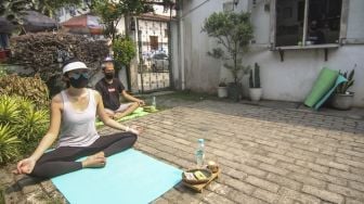 Pengunjung berjemur di halaman sebuah kedai kopi di Depok, Jawa Barat, Jumat (30/7/2021). [ANTARA FOTO/Asprilla Dwi Adha]