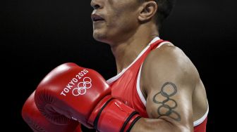 Tato Abdelhaq Nadir dari Maroko yang menggambarkan cincin Olimpiade saat melawan Louis Richarno Colin dari Mauritius selama pertandingan tinju kelas ringan putra selama Olimpiade Tokyo 2020 di Kokugikan Arena, Tokyo, pada (25/7/2021). [Luis ROBAYO / POOL / AFP]