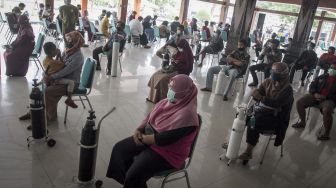 Warga mengantre untuk melakukan isi ulang oksigen pada kegiatan Bakti Sosial Oksigen Gratis di Rumah Dinas Bupati Karanganyar, Jawa Tengah, Jumat (30/7/2021). [ANTARA FOTO/Mohammad Ayudha]