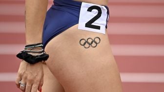 Tato Cincin Olimpiade Tokyo terlihat di kaki atlet Yunani Rafalia Spanoudaki-Chatziriga sebelum babak penyisihan 100 meter putri selama Olimpiade Tokyo 2020 di Stadion Olimpiade,Tokyo, pada (30/7/2021). [Ben STANSALL / AFP]