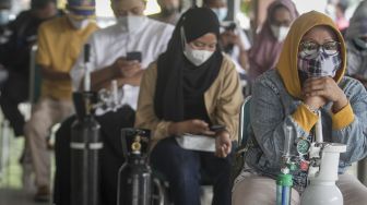 Warga mengantre untuk melakukan isi ulang oksigen pada kegiatan Bakti Sosial Oksigen Gratis di Rumah Dinas Bupati Karanganyar, Jawa Tengah, Jumat (30/7/2021). [ANTARA FOTO/Mohammad Ayudha]