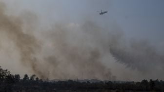 Helikopter Mi-8AMT melakukan pemadaman kebakaran lahan dari udara (water bombing) di Desa Palem Raya, Indralaya Utara, Ogan Ilir (OI), Sumatera Selatan, Sabtu (31/7/2021). [ANTARA FOTO/Nova Wahyudi]