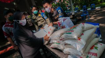 Petugas memberikan beras bantuan kepada warga penerima vaksin COVID-19 di Pendopo Kabupaten Lebak, Banten, Senin (2/8/2021). ANTARA FOTO/Muhammad Bagus Khoirunas