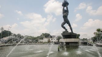 Petugas Dinas Pertamanan dan Kehutanan DKI Jakarta melakukan perwatan rutin kolam air mancur Patung Pemuda Membangun di Bundaran Senayan, Jakarta Pusat, Senin (2/8/2021). [Suara.com/Alfian Winanto]