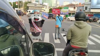 Maskot Hari Konsumen Nasional (Harkonas) Si Enda melakukan aksi kampanye kepada pengendara di kawasan Tugu Tani, Jakarta Pusat, Selasa (3/8/2021). [Suara.com/Alfian Winanto]