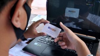 Petugas mencetak kartu sertifikat vaksinasi COVID-19 pesanan warga saat kegiatan vaksinasi COVID-19 massal di Denpasar, Bali, Selasa (3/8/2021). ANTARA FOTO/Fikri Yusuf