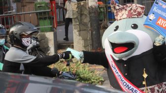 Maskot Hari Konsumen Nasional (Harkonas) Si Enda melakukan aksi kampanye kepada pengendara di kawasan Tugu Tani, Jakarta Pusat, Selasa (3/8/2021). [Suara.com/Alfian Winanto]