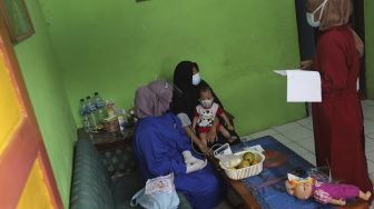 Relawan memeriksa kesehatan ibu menyusui penyintas COVID-19 di RW 07 Kelurahan Tengah, Kramat Jati, Jakarta Timur, Kamis (5/8/2021). [Suara.com/Angga Budhiyanto]