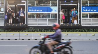 Penumpang menunggu Bus Transjakarta di halte Transjakarta Dukuh Atas, Jakarta Pusat, Jumat (6/8/2021). [Suara.com/Alfian Winanto]