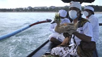 Umat Hindu menyiapkan sesajen dan binatang kurban yang akan ditenggelamkan ke laut saat rangkaian ritual upacara "Aci Pakelem Hulu-Teben ring Panca Segara" di perairan Kuta, Badung, Bali, Sabtu (7/8/2021). [ANTARA FOTO/Fikri Yusuf]