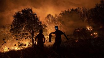 Warga mencoba memadamkan api yang menyebar di desa Akcayaka, Milas, Provinsi Mugla, Turki, pada (6/8/2021). [Yasin AKGUL / AFP]