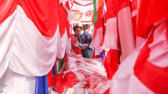 Pedagang bendera merah putih dan pernak-pernik 17 an menjajakan dagangannya di Jalan Matraman Raya, Jatinegara, Jakarta Timur, Minggu (8/8/2021). [Suara.com/Alfian Winanto]