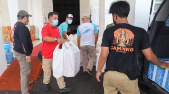  Petugas bersiap mendistribusikan nasi box di dapur umum Kementerian Sosial di Gedung Konvensi, Taman Makam Pahlawan (TMP) Kalibata, Jakarta, Minggu (8/8/2021). [Suara.com/Alfian Winanto]