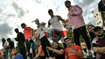 Fans PSG berkumpul dan bersorak di Parc des Princes menyambut kedatangan pemain anyar klub papan atas Liga Prancis itu, Lionel Messi, Selasa (10/8/2021).  [AFP Photo]