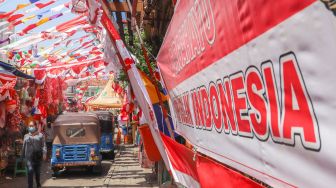 Suasana area pasar yang dipenuhi ornamen dan pernak-pernik bendera merah putih di Pasar Jatinegara, Jakarta Timur, Rabu (11/8/2021). [Suara.com/Alfian Winanto]