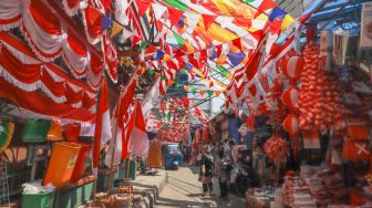 Suasana area pasar yang dipenuhi ornamen dan pernak-pernik bendera merah putih di Pasar Jatinegara, Jakarta Timur, Rabu (11/8/2021). [Suara.com/Alfian Winanto]