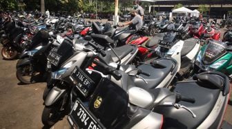 Calon peserta lelang didampingi tenaga marketing melihat langsung unit motor yang akan dilelang sebelum pelaksanaan pelelangan di Pasar Lelang Motor Universal Ciputat, Tangerang Selatan, Banten, Kamis (13/8/2021). ANTARA FOTO/Muhammad Iqbal