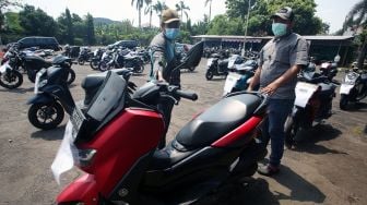 Calon peserta lelang didampingi tenaga marketing melihat langsung unit motor yang akan dilelang sebelum pelaksanaan pelelangan di Pasar Lelang Motor Universal Ciputat, Tangerang Selatan, Banten, Kamis (13/8/2021). ANTARA FOTO/Muhammad Iqbal