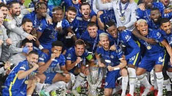 Para pemain Chelsea berpose dengan trofi selama upacara penyerahan setelah Chelsea memenangkan pertandingan sepak bola Piala Super UEFA antara Chelsea melawan Villarreal di Windsor Park, Kamis (12/8) dini hari WIB. [Paul ELLIS / AFP]