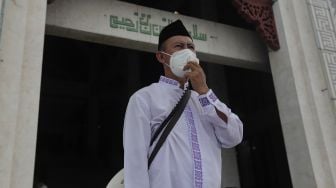 Pengurus masjid memberikan imbauan untuk mematuhi protokol kesehatan kepada jamaah yang akan menunaikan sholat Jumat berjamaah di Masjid At-Tin, Jakarta, Jumat (13/8/2021). [Suara.com/Angga Budhiyanto]