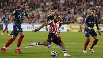 Gelandang Brentford Bryan Mbeumo (tengah) melakukan tendangan selama pertandingan sepak bola Liga Premier Inggris antara Brentford dan Arsenal di Brentford Community Stadium, London, pada (13/8/2021). [Adrian DENNIS / AFP]