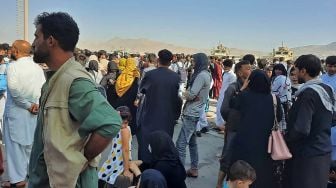 Warga berkumpul Bandara Internasional Hamid Karzai di Kabul, Afghanistan, Senin (16/8/2021).  [AFP Photo]