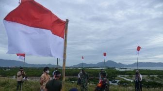 Sejumlah jurnalis dari berbagai media yang tergabung dalam Komunitas Pena Emas Aceh bersama TNI bersiap melaksanakan upacara pengibaran bendera di Bukit Pengolahan Sampah kawasan pesisir pantai, Kampung Jawa, Banda Aceh, Senin (16/8/2021). ANTARA FOTO/Ampelsa
