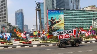 Komunitas Mobil Klasik melintas di kawasan Bundaran Hotel Indonesia (HI), Jakarta Pusat, Selasa (17/8/2021). [Suara.com/Alfian Winanto]