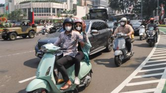 Komunitas Motor Vespa melintas di kawasan Bundaran Hotel Indonesia (HI), Jakarta Pusat, Selasa (17/8/2021). [Suara.com/Alfian Winanto]