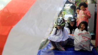 Anak-anak mengikuti lomba balap karung di Menteng, Jakarta, Selasa (17/8).  [Suara.com/Oke Atmaja]
