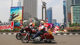 Komunitas Motor Gede (Moge) melintas sambil mengibarkan bendera merah putih di kawasan Bundaran Hotel Indonesia (HI), Jakarta Pusat, Selasa (17/8/2021). [Suara.com/Alfian Winanto]