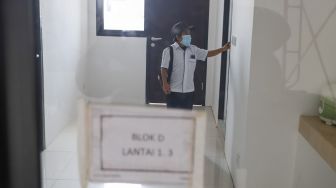 Petugas menunjukkan bagian dalam rumah di Kampung Susun Akuarium, Penjaringan, Jakarta Utara, Rabu (18/8/2021). [Suara.com/Alfian Winanto]