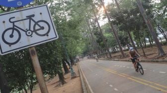 Warga berolahraga sepeda di Jalur Banjir Kanal Timur, Jakarta Timur, Kamis (19/8/2021). [Suara.com/Alfian Winanto]