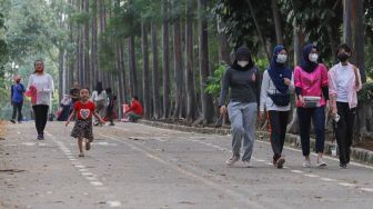 Warga berolahraga sore di Jalur Banjir Kanal Timur, Jakarta Timur, Kamis (19/8/2021). [Suara.com/Alfian Winanto]