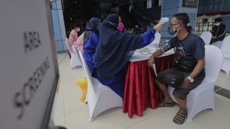 Petugas kesehatan memeriksa kondisi kesehatan warga yang akan mendapatkan vaksinasi COVID-19 di Stasiun Juanda, Jakarta, Jumat (20/8/2021). [Suara.com/Angga Budhiyanto]