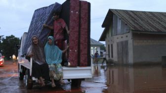 Warga menyelamatkan barang dari banjir di Desa Wanoamonapa, Kecamatan Pondidaha, Konawe, Sulawesi Tenggara, Sabtu (21/8/2021). [ANTARA FOTO/Jojon]