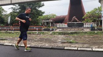 Warga berolahraga sore di kawasan Taman Mini Indonesia Indah, Jakarta Timur, Sabtu (21/8/2021). [Suara.com/Alfian Winanto]