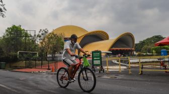 Warga berolahraga sore di kawasan Taman Mini Indonesia Indah, Jakarta Timur, Sabtu (21/8/2021). [Suara.com/Alfian Winanto]