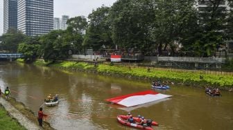 Gabungan relawan rescue membentangkan bendera Merah Putih ukuran 10x5 meter di Kali Ciliwung, Jakarta, Minggu (22/8/2021). [ANTARA FOTO/Galih Pradipta]