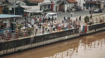 Sejumlah warga berolahraga di pinggir Sungai Cisadane, Kota Tangerang, Banten, Minggu (22/8/2021). [Suara.com/Hilal Rauda Fiqry]