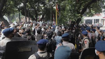 Petugas kepolisian membubarkan paksa pengungsi Afghanistan yang menggelar aksi unjuk rasa di depan Gedung UNHCR, Kebon Sirih, Jakarta, Selasa (24/8/2021). [Suara.com/Angga Budhiyanto]