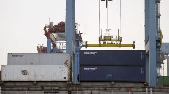 Seorang pekerja menyaksikan bongkar muat peti kemas di Pelabuhan Tanjung Priok, Jakarta, Selasa (24/8/2021).  ANTARA FOTO/M Risyal Hidayat