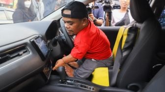 Komedian Ucok Baba mencoba mobil barunya saat ditemui di Cafenya di Kawasan Cipayung, Depok, Jawa Barat, Rabu (25/11/2021). [Suara.com/Alfian Winanto]