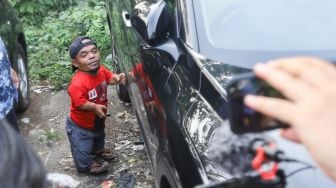 Komedian Ucok Baba mencoba mobil barunya saat ditemui di Cafenya di Kawasan Cipayung, Depok, Jawa Barat, Rabu (25/11/2021). [Suara.com/Alfian Winanto]